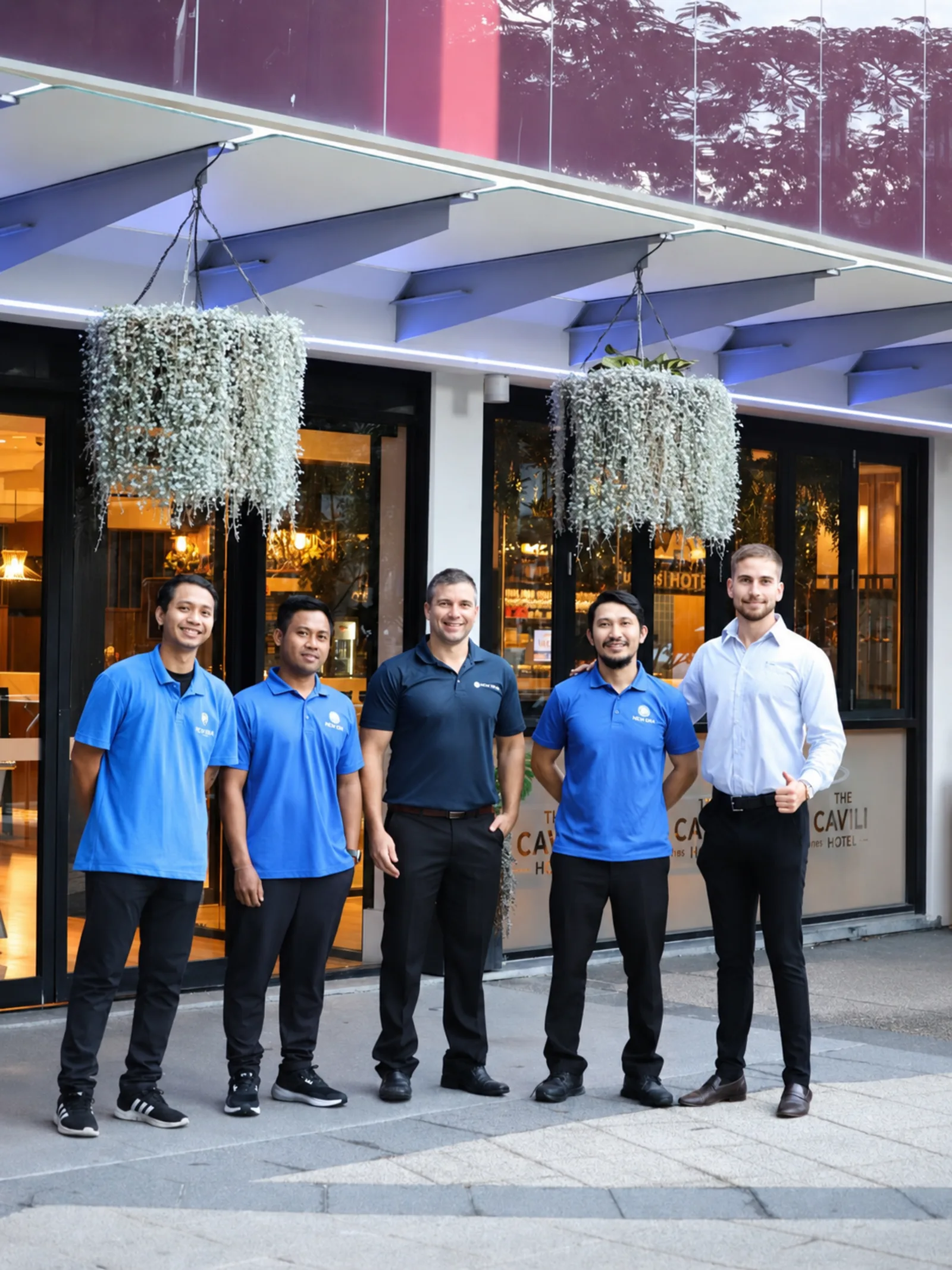 A New Era service and management team standing together at the entrance of a hotel they service